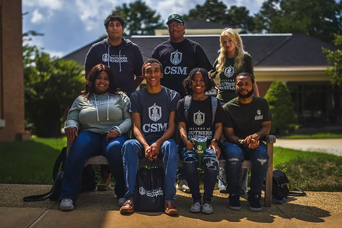 Group of students smiling wearing CSM gear